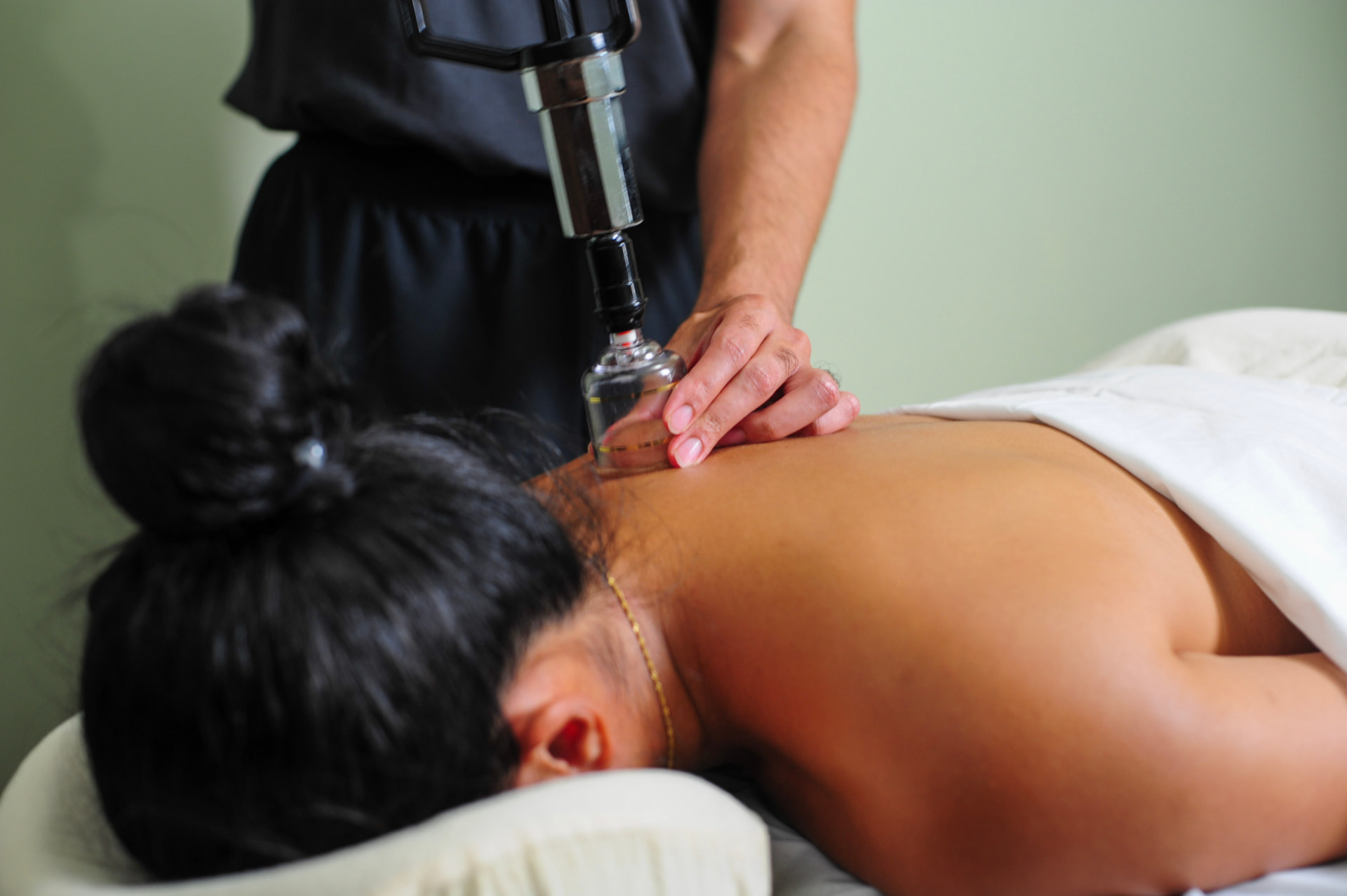 Registered massage therapist performing hands-on deep tissue treatment on a client's back